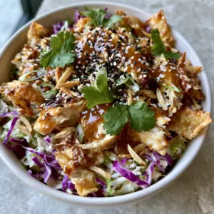 Close up of Chinois Chicken Salad featuring moist rotisserie chicken chunks and vibrant purple cabbage slivers. (Chinois Chicken Salad)
