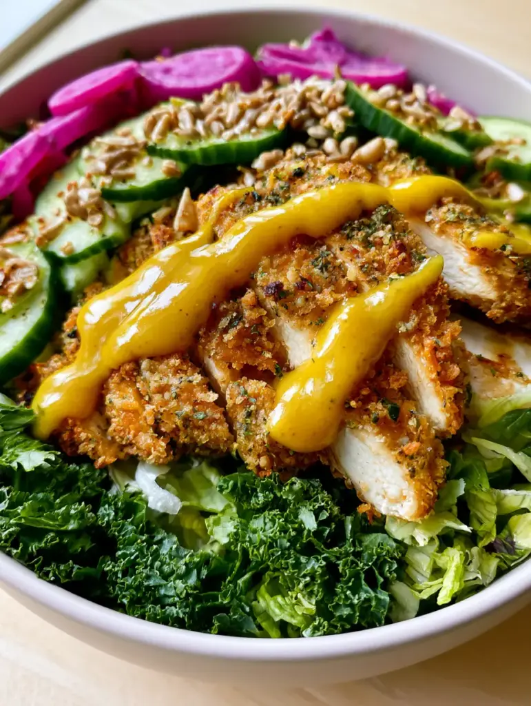 Detailed view of shaved cucumber ribbons and purple radish rounds on a crispy chicken crunch salad.