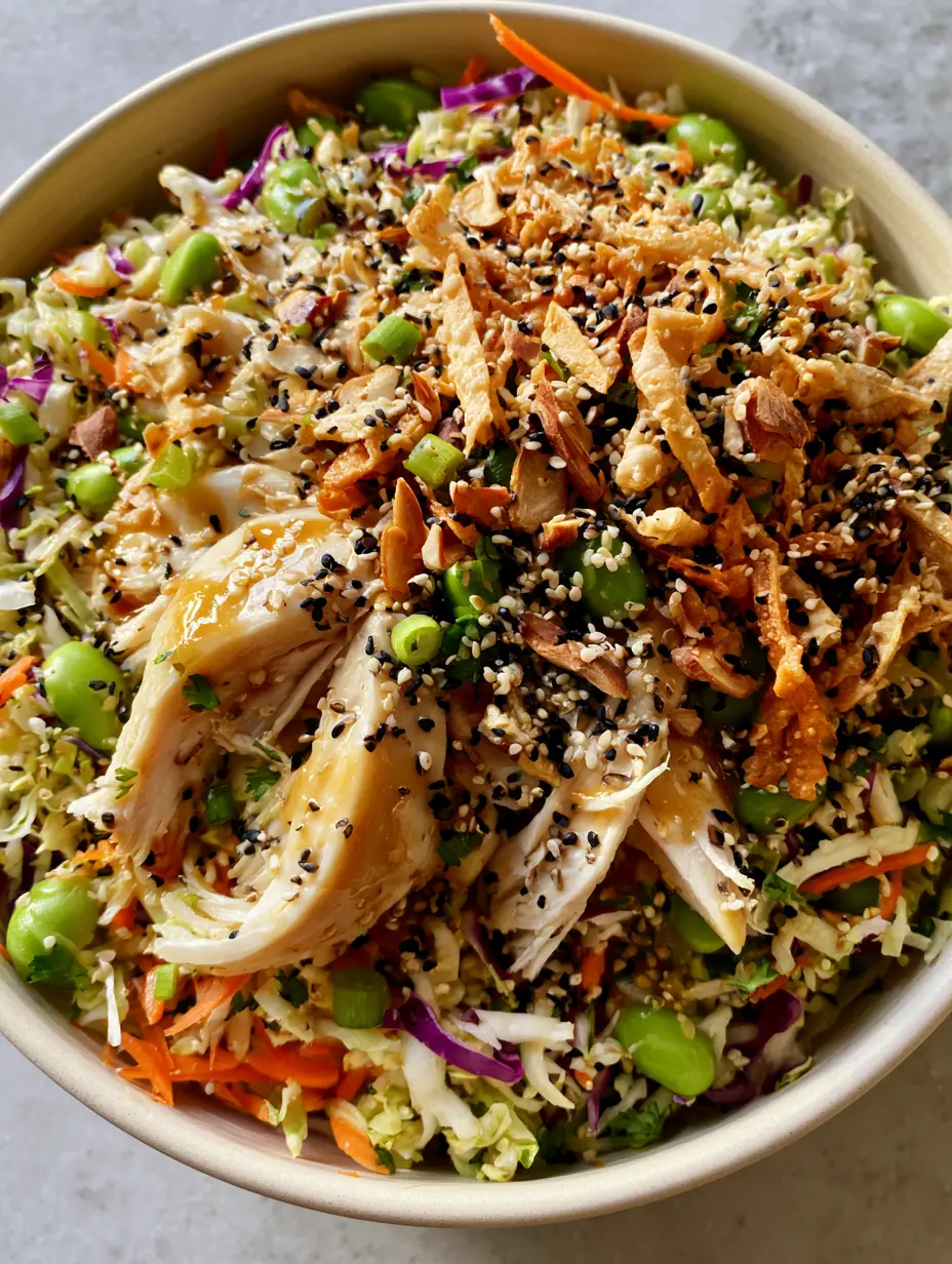 Extreme close-up of vibrant Asian crunch chicken salad textures including purple cabbage and golden wonton strips.