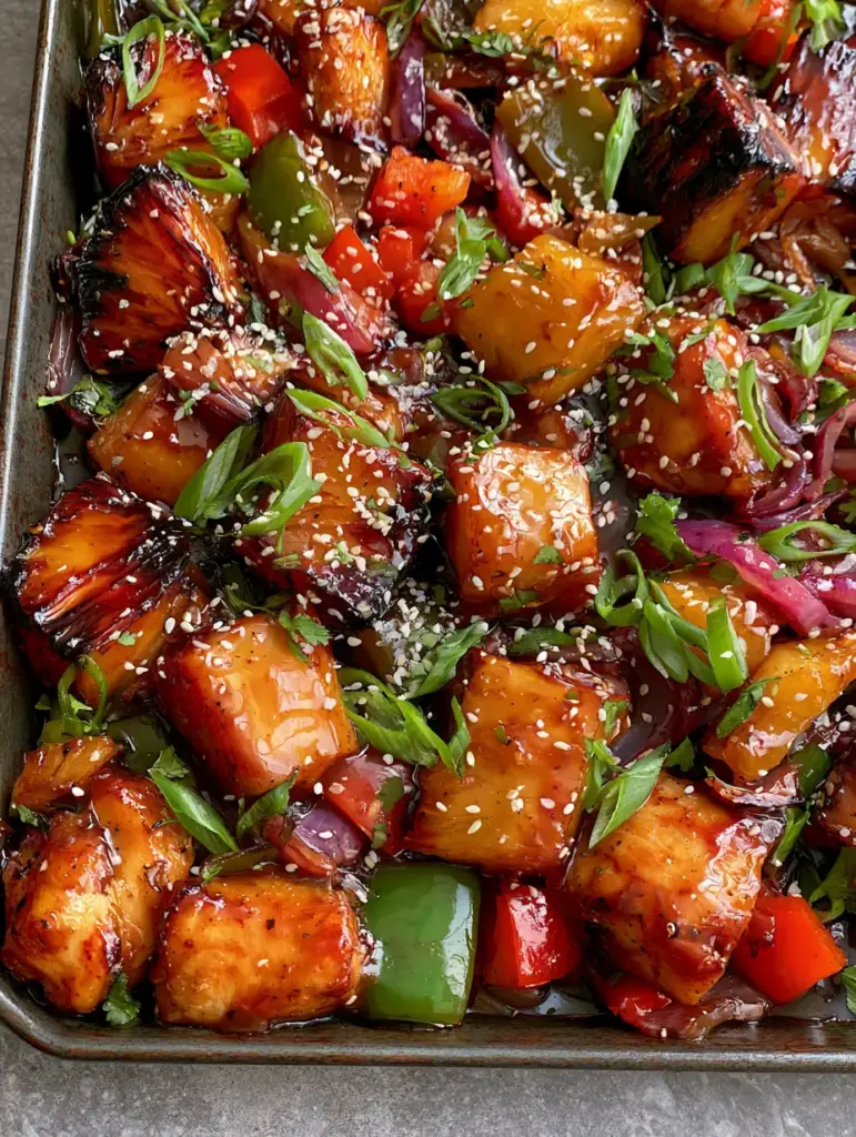 Pineapple Chicken Teriyaki with Roasted Peppers and Charred Pineapple 1 Rustic sheet pan with roasted red and green bell peppers, red onions, and charred pineapple chunks in pineapple chicken teriyaki.