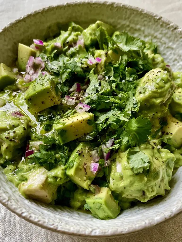 Avocado Chicken Salad Recipe: The Ultimate Creamy and Healthy Gourmet Guide 1 A top-down view of a rustic ceramic bowl filled with creamy avocado chicken salad and a heavy scatter of cilantro.