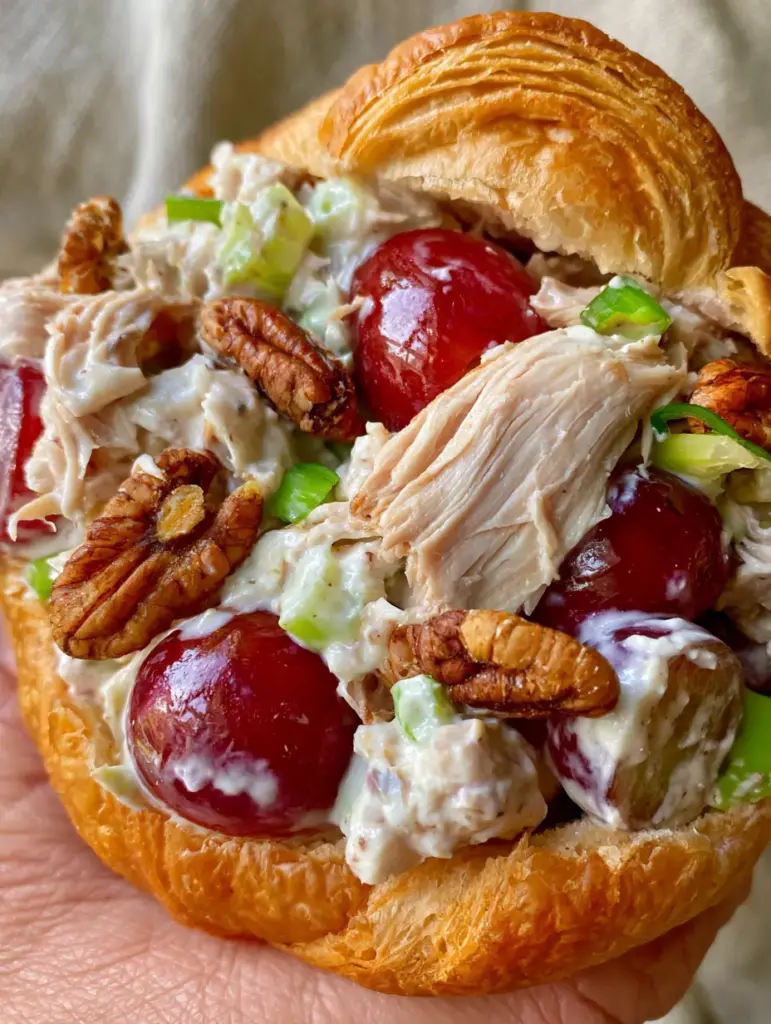 Detailed shot of shredded chicken, celery, and toasted pecans in a Grape Chicken Salad sandwich.