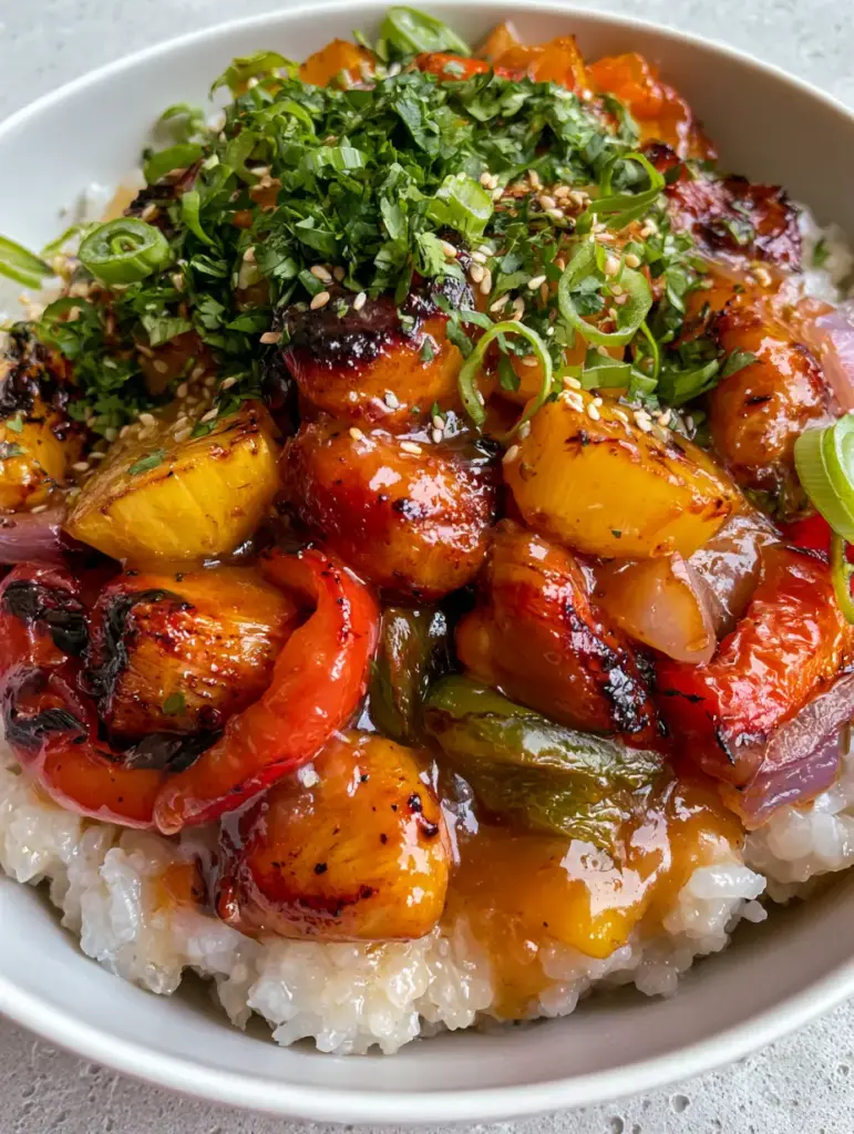 Hawaiian Chicken with Coconut Rice: The Ultimate Tropical Bowl Recipe 1 Overhead view of a Hawaiian chicken bowl with blistered red and green bell peppers and toasted sesame seeds.