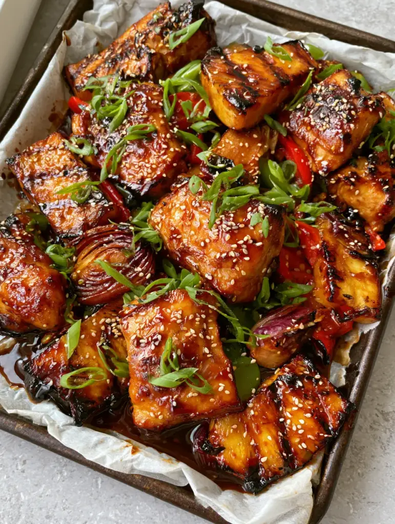 Gluten-free Hawaiian Chicken with Caramelized Pineapple and Glossy Teriyaki Glaze 1 Top down view of charred red and green bell peppers and pineapple wedges with distinct grill marks. (Gluten-free Hawaiian Chicken)